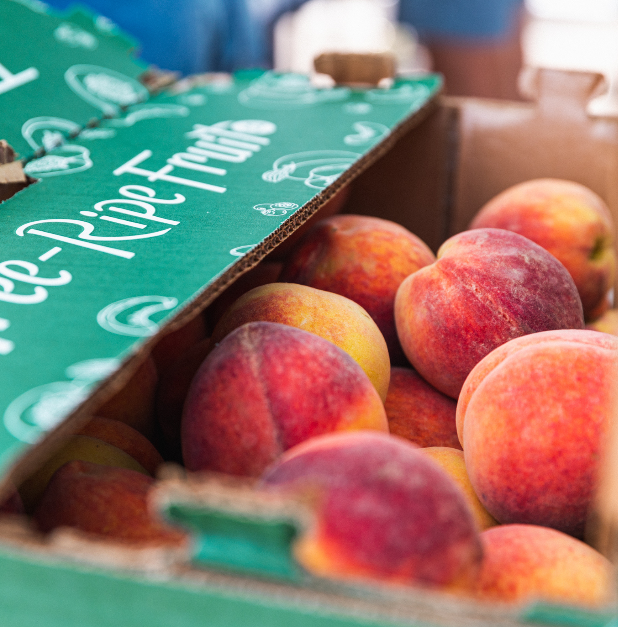 Ripe peaches inside a Tree-Ripe branded box