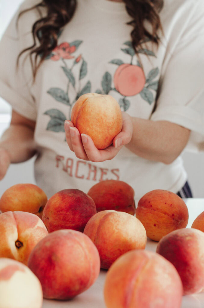 Hand holding peach in the kitchen